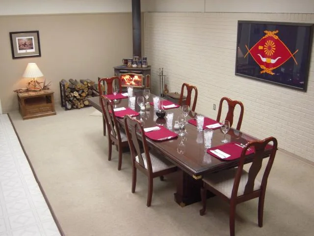 Archival dining room with a long table set beside a wood-burning stove